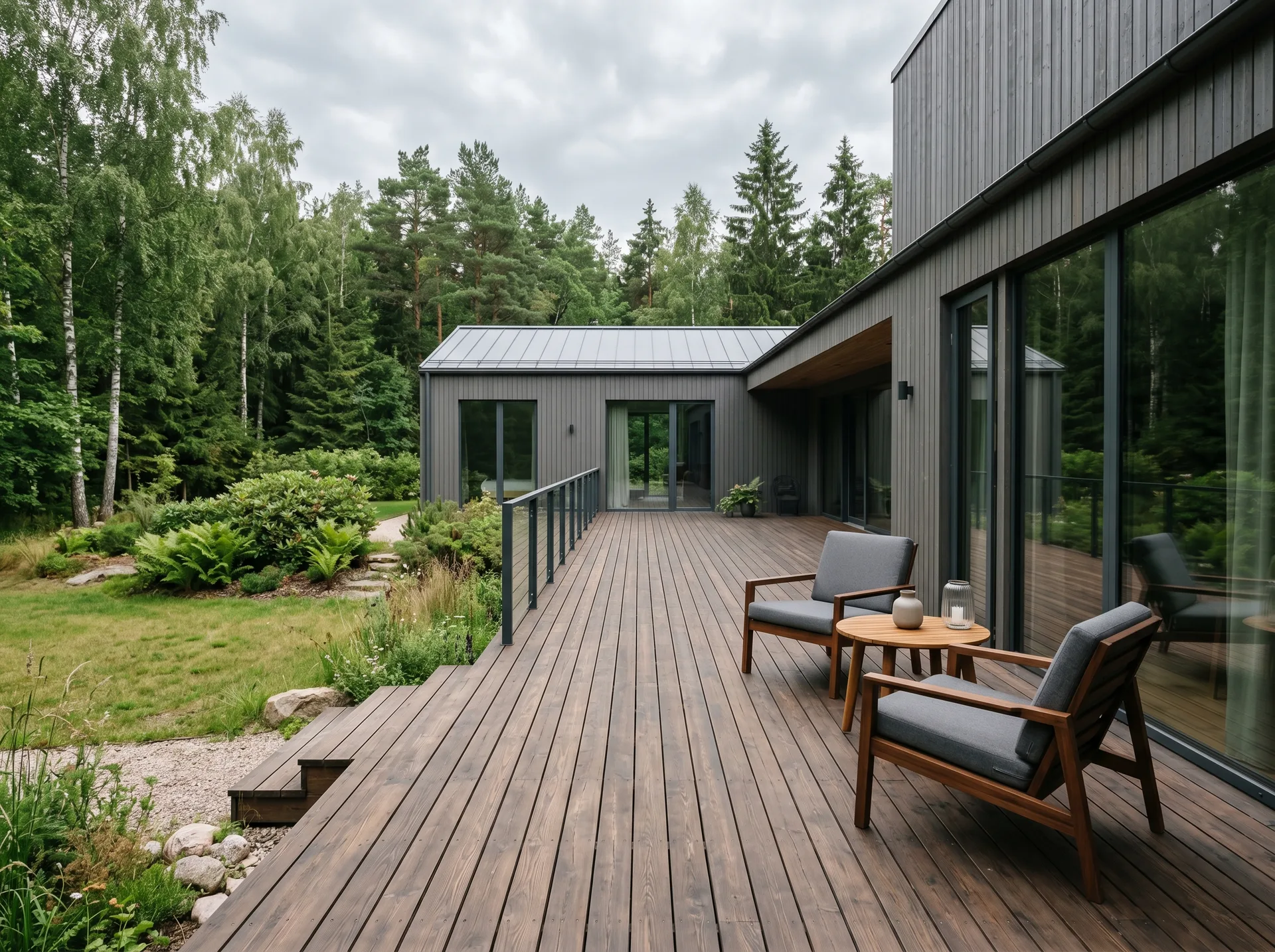 Moodne puitterrass tumeda eramaja kõrval metsases aias